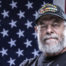 Veteran standing in front of American flag